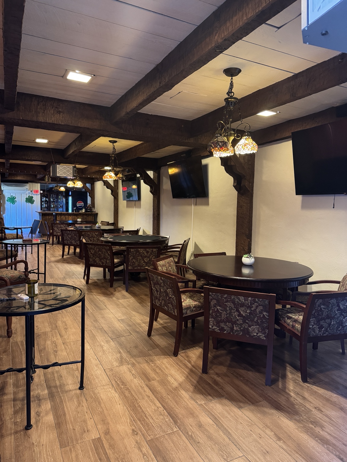 Embers Vine cigar lounge with wood beams, stained-glass chandeliers, tables and upholstered seating