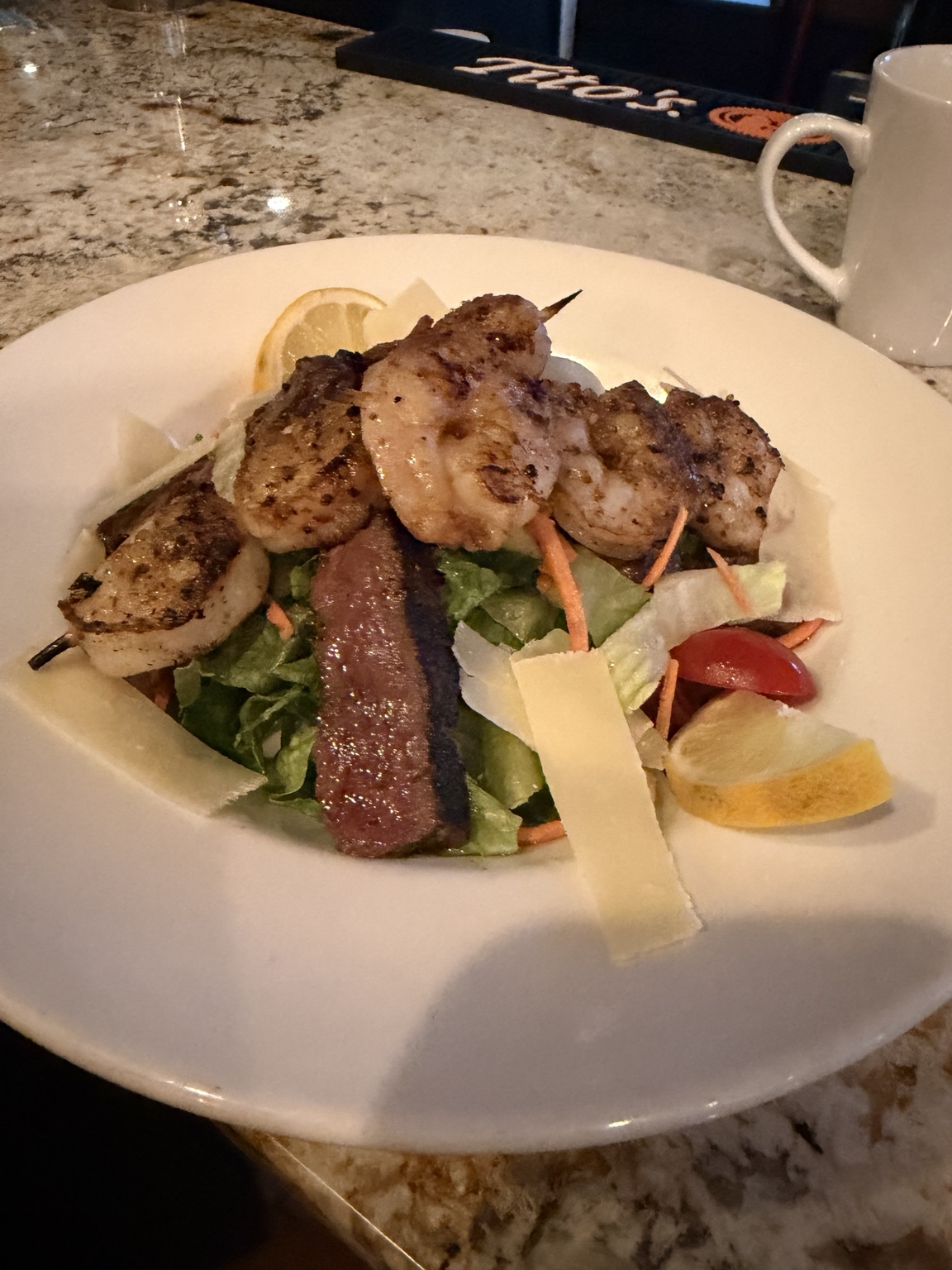Embers Vine surf-and-turf salad with steak, grilled shrimp, greens, shaved cheese and lemon